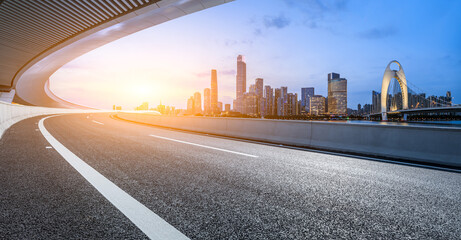 Asphalt highway road and bridge with modern city buildings at sunset in Guangzhou. Panoramic view. © ABCDstock