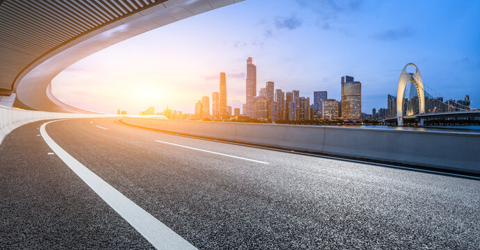 Asphalt highway road and bridge with modern city buildings at sunset in Guangzhou. Panoramic view.