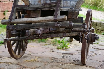 Antique wagon with logs on it in a rural landscape