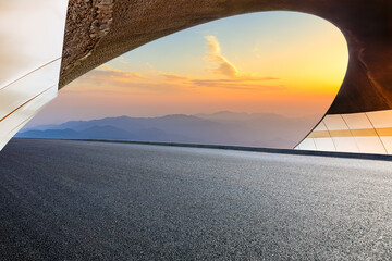 Asphalt highway and tunnel exit with mountain at sunset