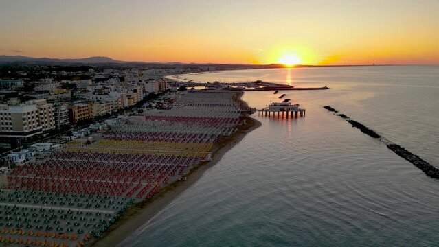 Drone shot of sunset on the Romagna Riviera coast from Gabicce Mare town to Rimini city in Italy