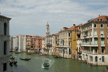 View of a river in Venice, featuring several boats of different sizes and colors, sailing in water