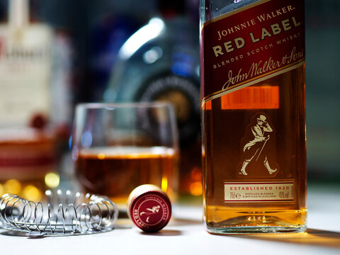 In this photo illustration, a bottle of  Johnnie Walker Red Label, Blended Scotch Whisky seen displayed on a table.