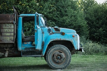 Vintage weathered old blue truck on a grassy field