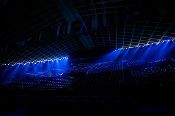 Illuminated empty blue stadium with a large stage