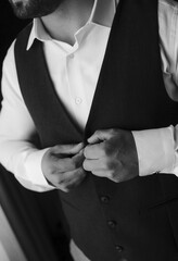 Vertical of a groom hearing classic suit in grayscale