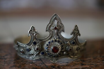 the silver crown sits on top of a wooden table with a metal band around it