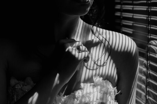 a black and white image of a bride holding her bouquet