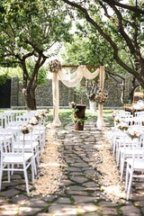 Fototapeta na wymiar a wedding ceremony in an open garden area, with white chairs and table cloths