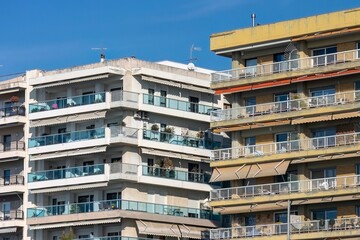 Obraz premium Scenic view of two residential buildings next to each other under a blue sky.