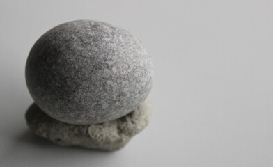 Fototapeta na wymiar Single Zen Stone On White Surface At A Side Of Image Stock Photo For Backgrounds 