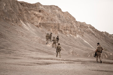 Soldiers in camouflage uniforms aiming with their rifles.ready to fire during military operation in...