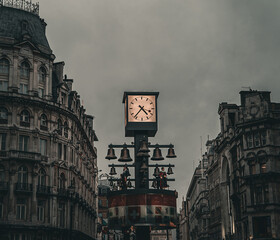Obraz premium Clock outdoors in the city center of Leicester Square, London, dramatic colors, cloudy weather, evening