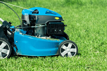 Lawn mower cutting grass. Small grass cuttings fly out of lawnmower. Grass clippings get spewed out...