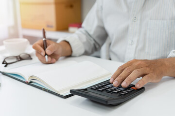 Focused on calculating personal income tax using a calculator, this business professional delves into financial planning with precision and dedication.