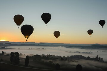 balloons ascending with a fogcovered landscape below at dawn