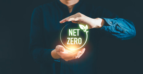 Businessman holding net zero icon with globe outline background for Net zero and carbon neutral concept. Net zero greenhouse gas emissions target. Climate neutral long term strategy.