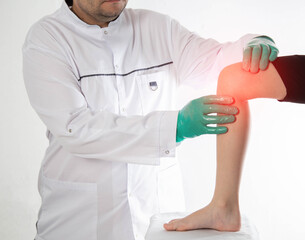 A doctor traumatologist orthopedist examines the knee joint of a child who has knee pain. Concept...
