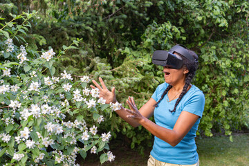 woman with virtual reality goggles regards garden plants