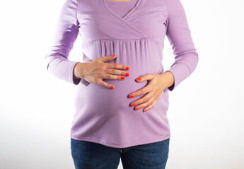A pregnant girl with a purple sweater holds her swollen belly. Concept of digestive problems in pregnant women, flatulence and heartburn. Constipation in pregnant women, close-up
