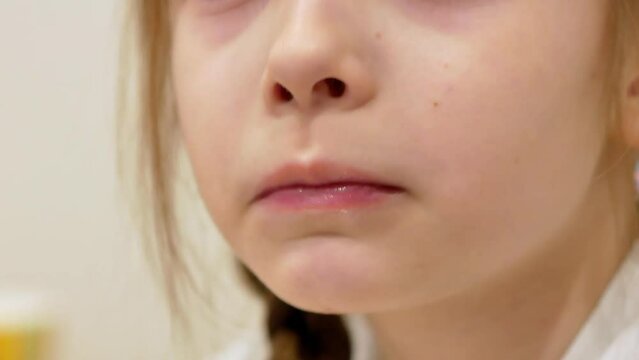 The moist lips of a child who chews food, eats, licks his lips with his tongue, delicious food.
