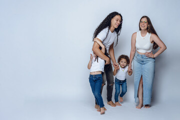 young latin family of father mother and two daughters, having fun posing and smiling, studio shot