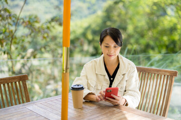 Woman use of mobile phone in outdoor coffee shop