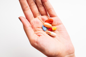 A Woman's hand holding multiple pill isolated on white background