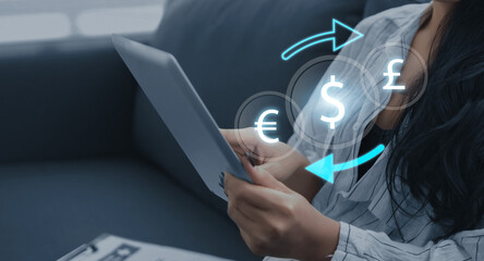 Currency exchange financial banking interbank foreign exchange and payment concept, with a businessman holding currency and using a digital tablet with finger pointing at symbols.