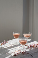 Rose wine in vintage glasses, romantic mood, spring vibes tenderness and sunny morning light, romantic mood. Eco linen background, natural spring light.  Romantic still life, interior  
