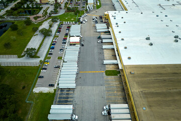 Aerial view of large commercial loading bay with many delivery trucks unloading and uploading...