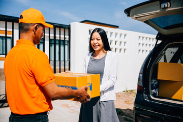 Customer satisfaction highlighted as a delivery service courier hands a cardboard parcel to a...
