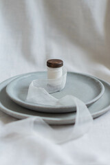 A composition of ceramic dishware in varying shades of muted gray, artistically arranged on a...