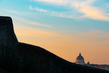 Fototapeta premium St. Peter cupola appears behind a wall of Clivo Rocca Savella on the Aventino hill of Rome