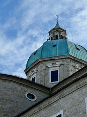 View of the dome of Bürgerspitalkirche St. Blasius in Salzburg, Austria, with a clear sky as the background, highlighting its architectural beauty.