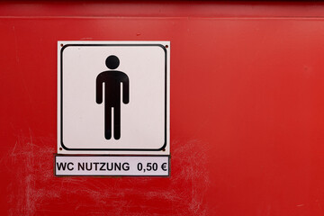 Schild mit der deutschen Aufschrift WC Nutzung 0,50 € an einer Toilette für Männer - 768910347