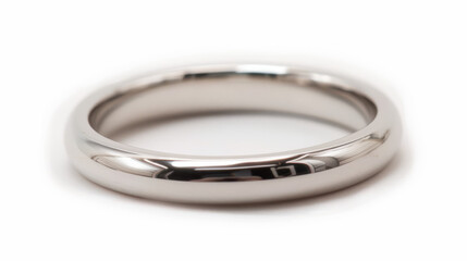 Close up of a perfectly polished silver ring with a soft shadow and reflection on a plain white background