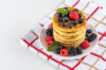 Delicious pancakes with fresh berries on white table. Food concept.