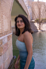 Obraz premium A woman in a blue dress stands in front of a brick wall