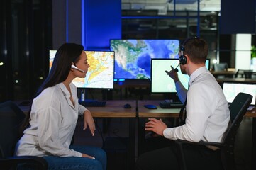 Center of dispatching maintenance. Portrait of cheerful woman and man working via headset...