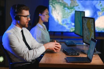 Male Data Scientist Works on Personal Computer Control and Monitoring Room. Map Surveillance of...