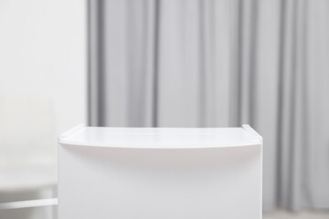 White ballot box on blurred background, closeup. Space for text