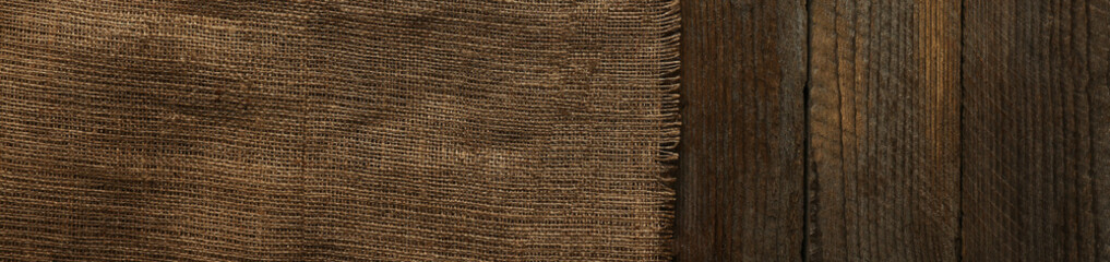 Burlap fabric on wooden table, top view. Space for text