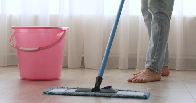 caucasian woman cleaning and mopping floor at the room, daily housekeeping , close-up