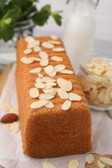 Cake with fresh almond flakes on table, closeup