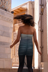 Fototapeta premium A woman in a blue and white dress is walking down a street
