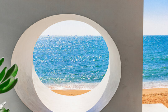 Beach at World's End Park, Sanya, China. View of a beautiful and sea through a round hole in a wall.