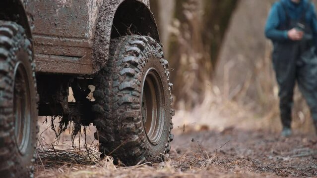 a four-wheel drive all-terrain vehicle drives through the forest through the mud. a passable SUV with large wheels and high clearance. special transport for foresters rides through swamps and mud