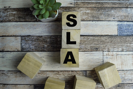 Concept of The wooden Cubes with the word SLA - Service Level Agreement on wooden background.