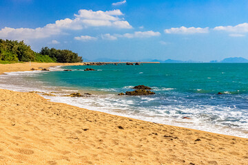 View of the shore of the South China Sea with a sandy beach and large rocks. Sanya, China.